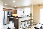 Step into our beautiful, well-equipped kitchen with a convenient breakfast bar perfect for enjoying a light meal. This photo showcases the modern appliances and ample counter space, making meal preparation a breeze. A chef`s delight